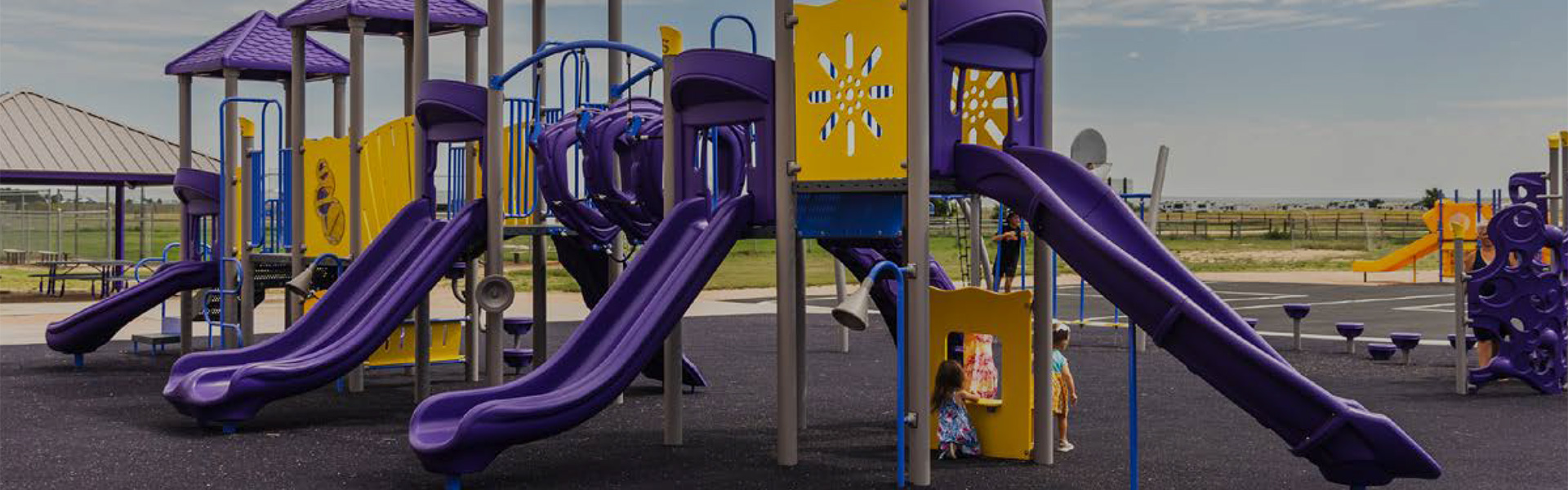 Superior Recreation of the Carolinas bright purple and yellow playground with multiple slides at a community park in North Carolina.