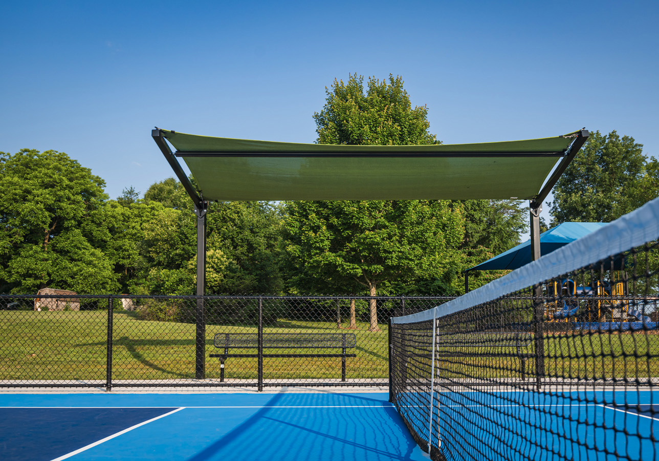 Covered seating area with shade canopy by the pickleball courts at Fairchild Pickleball & Tennis in Burlington, NC.