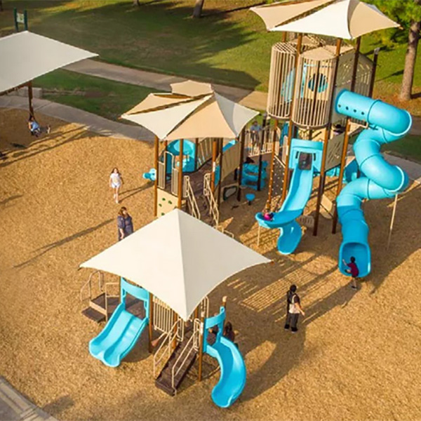 Aerial view of blue playground with multiple slides and shade structures by Superior Recreation of the Carolinas.