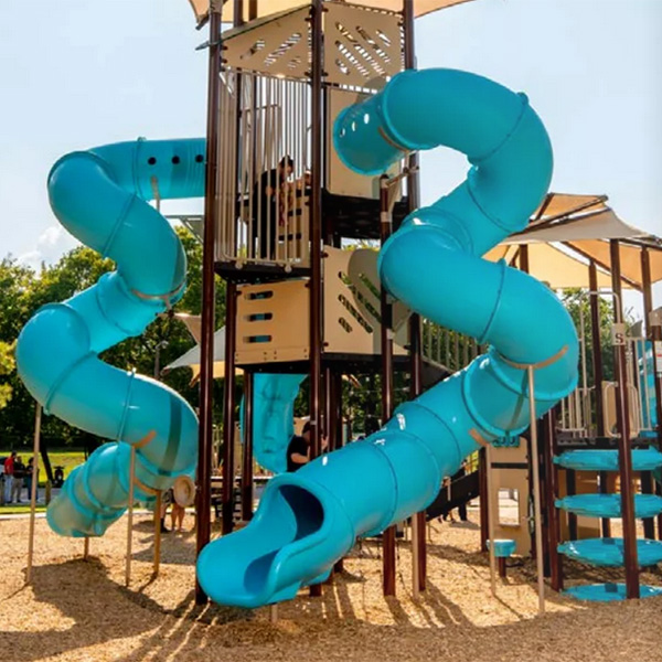 Tall playground tower with dual turquoise tube slides over a mulch surface.