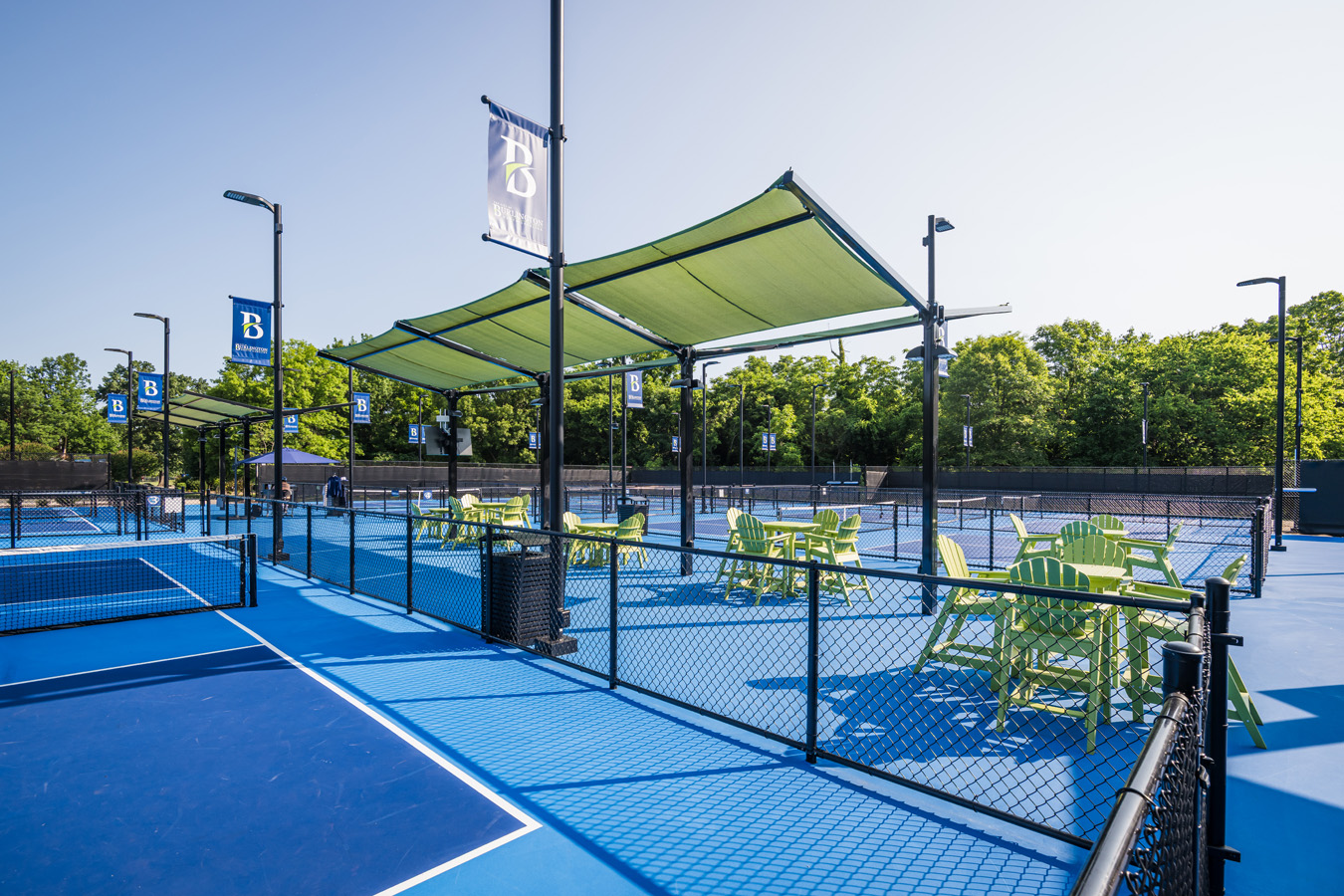 Outdoor pickleball courts with shaded seating areas and Burlington banners at city recreation complex.