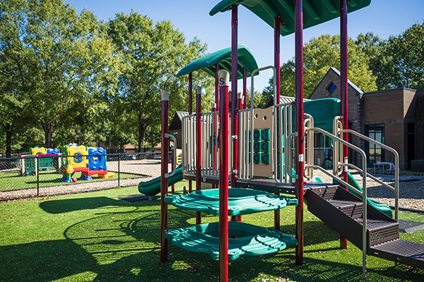 SR Carolinas playground climbing structure with green platforms and slides in The Carolinas