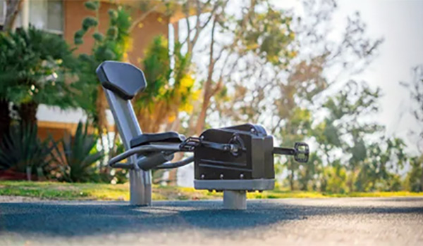 Outdoor fitness equipment rowing machine installed on rubber surfacing by Superior Recreation.