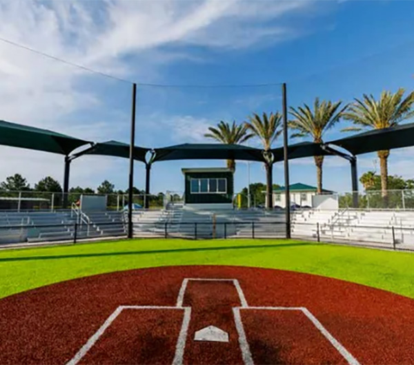 Baseball field with aluminum bleachers and protective shade structures by Superior Recreation of the Carolinas in South Carolina.